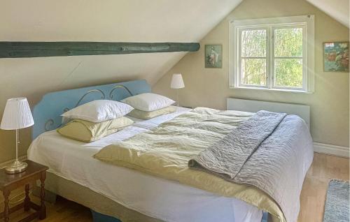 a bedroom with a bed with a blue headboard and pillows at 3 Bedroom Pet Friendly Home In Skldinge in Sköldinge