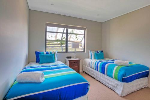 - une chambre avec 2 lits et une fenêtre dans l'établissement Loka Santi 10 - Beachfront unit, à Agnes Water
