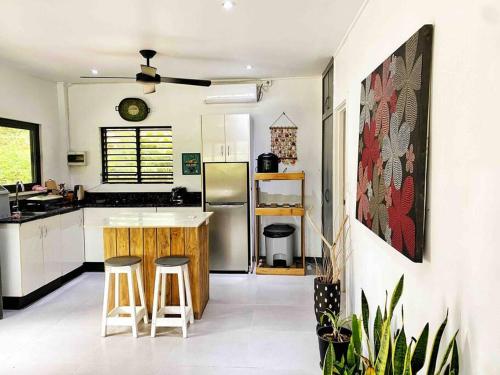 una cucina con bancone e sgabelli di Art & Soul Villa a Pacific Harbour