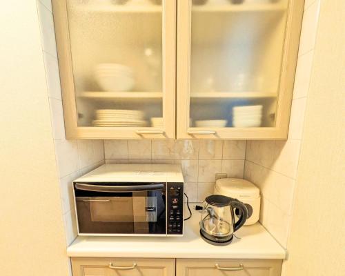 encimera de cocina con microondas y cafetera en The Global Tower, en Niihama