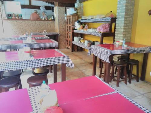 a restaurant with pink tables and chairs in a room at Apart Hotel Casa Grande in Natal
