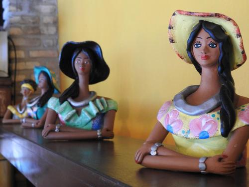 three dolls sitting on top of a table at Apart Hotel Casa Grande in Natal