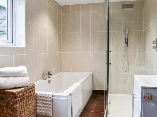 a bathroom with a bath tub and a shower at Summerville Cottage in Kirkby Stephen