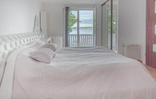 een wit bed met kussens in een slaapkamer bij 3 Bedroom Gorgeous Home In Bankeryd in Bankeryd