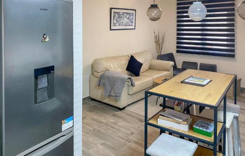 two pictures of a living room with a couch and a table at 3 Bedroom Amazing Apartment In Luanco in Luanco