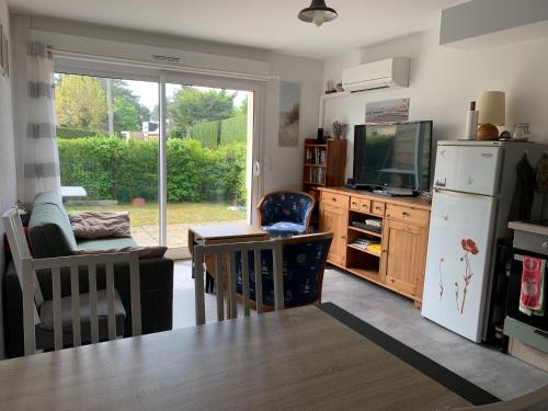 Il comprend une cuisine équipée d'un réfrigérateur, d'une table et d'une télévision. dans l'établissement Maison Familiale entre Plage et Baie d'Authie, Jardin Sud, Parking Privé, 2 Chambres - FR-1-482-33, à Fort-Mahon-Plage