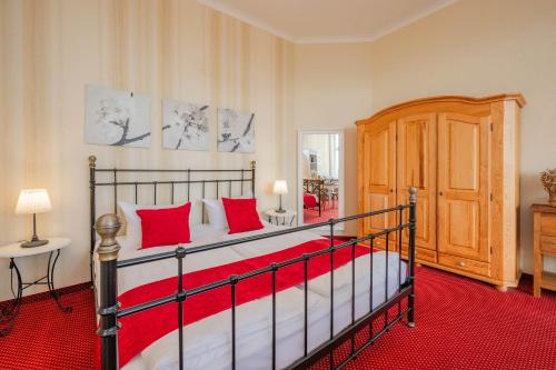 una camera da letto con un grande letto con cuscini rossi di Strandvillen Wald & See - 04 a Zinnowitz