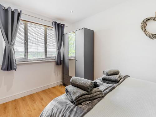 a bedroom with white walls and a bed with pillows at Open Hearth Cottage in Cardiff