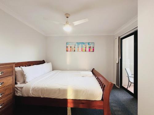 a small bedroom with a bed and a window at Seaside Oasis 2Beds Apt with Free Parking in Gold Coast