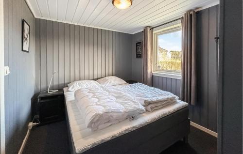 Gorgeous Home In Lindesnes With Kitchen في Spangereid: سرير صغير في غرفة مع نافذة