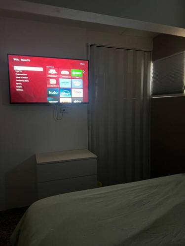 ein Schlafzimmer mit einem großen Bildschirm an der Wand in der Unterkunft Villa Orquídea 4 in Humacao