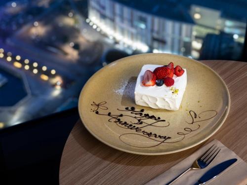 un plato con un trozo de pastel con bayas. en Mitsui Garden Hotel Toyosu Premier - Tokyo en Tokio