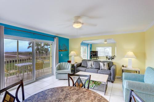 a living room with a couch and a balcony at South Beach Condo Hotel by Travel Resort Services, Inc. in St Pete Beach