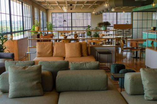 a large room with couches and tables and windows at Blend Coliving One - 2a in Ribeirão Preto