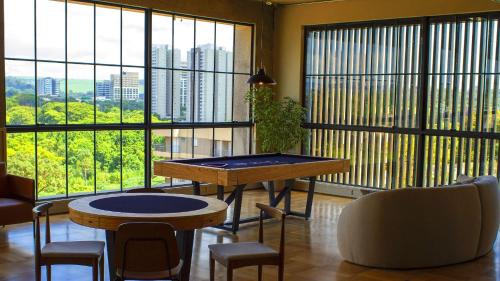 a room with a table and chairs and large windows at Blend Coliving One - 2a in Ribeirão Preto