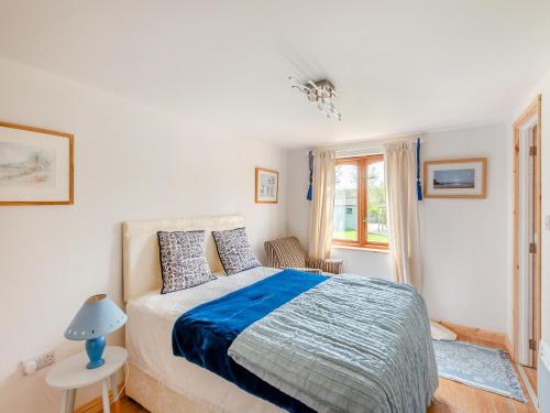 a bedroom with a large bed and a window at River Cabin in Little Baddow