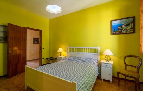 a yellow bedroom with a bed and a chair at Amazing Apartment In Montefelcino in Montefelcino