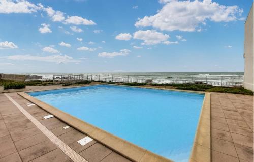 a swimming pool with the ocean in the background at Nice Apartment In Les Sables-D'olonne in Les Sables-dʼOlonne