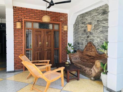 a patio with two chairs and a brick wall at San-Khara in Ahangama