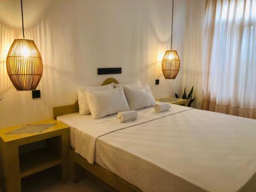 a bedroom with a large bed with two towels on it at San-Khara in Ahangama