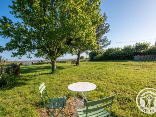 a table and two chairs in a field with a tree at Gîte charmant entre Loire et Layon, terrasse, jardin, parking, proche d'Angers, idéal pour couples - FR-1-622-71 in Rochefort-sur-Loire