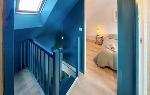 a room with a blue wall and a bedroom with a bed at 4 Bedroom Amazing Home In Plouézec in Plouézec