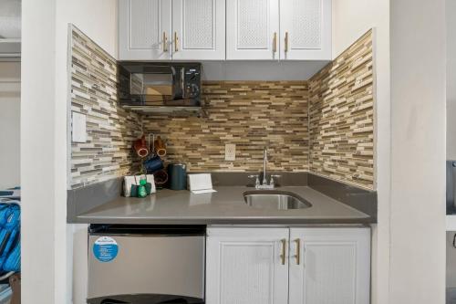 a kitchen with a sink and a brick wall at Sandestin Bayfront Studio with balcony and breathtaking views in Destin