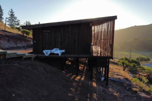 a small building with two benches on a hill at Casablanca Tiny Home con Hot tub in Lagunillas