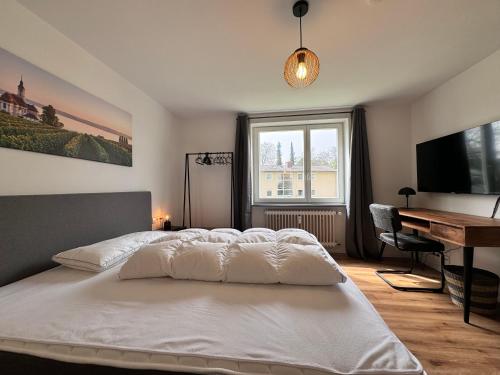 um quarto com uma cama, uma secretária e uma janela em Rauenstein em Überlingen