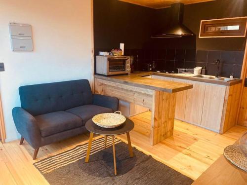 a living room with a blue couch and a kitchen at Casablanca Tiny Home con Hot tub in Lagunillas