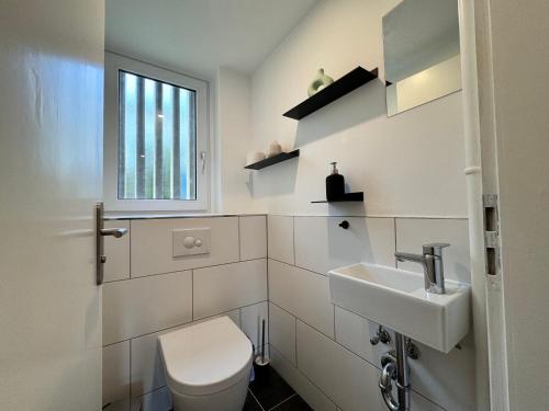 uma casa de banho branca com um WC e um lavatório em Rauenstein em Überlingen