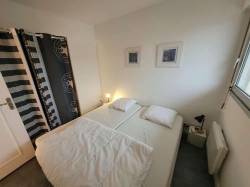 une petite chambre avec deux lits et une fenêtre dans l'établissement Appartement soigné à deux pas de la mer, balcon ensoleillé, confort et tranquillité à Wimereux - FR-1-675-37, à Wimereux