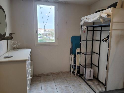 une petite pièce avec un lit et une fenêtre dans l'établissement Charmant F3 Mezzanine avec Piscine, Clim, Proche Plage et Centre - 4 Pers. - FR-1-559-35, à Palavas-les-Flots