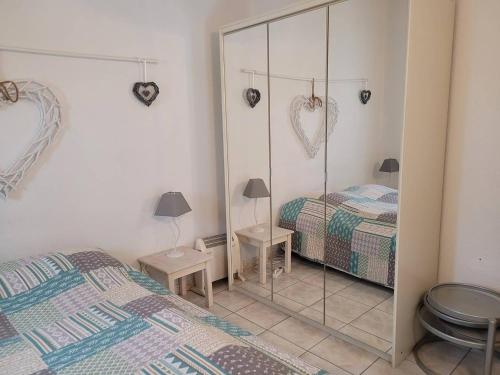 - une chambre avec 2 lits et un miroir mural dans l'établissement Charmant F3 Mezzanine avec Piscine, Clim, Proche Plage et Centre - 4 Pers. - FR-1-559-35, à Palavas-les-Flots
