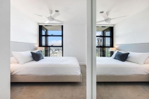 - une chambre avec 2 lits et un miroir dans l'établissement City Bloom - A Cosy Haven in Melbourne's Epicentre, à Melbourne