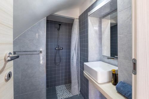 un bagno con lavandino e doccia di Ibla nel Cuore a Ragusa