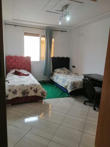 1 dormitorio con 2 camas y piano en Apparemment à louer, en Oujda