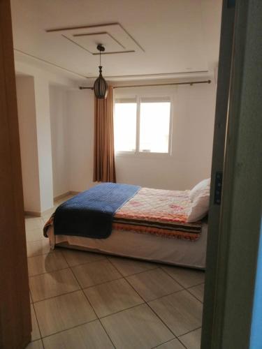1 dormitorio con 1 cama frente a una ventana en Apparemment à louer, en Oujda