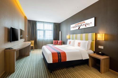 a hotel room with a large bed and a television at Wanda YUE Changbaishan in Baishan
