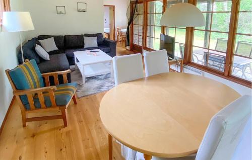LöderupにあるNice Home In Lderup With 2 Bedroomsのリビングルーム(テーブル、ソファ付)