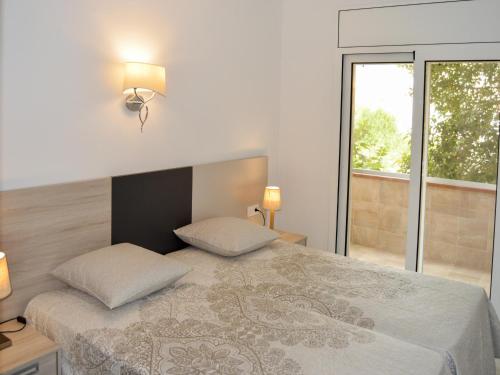 um quarto com uma cama com duas almofadas e uma janela em Appartement Empuriabrava, 4 pièces, 6 personnes - HISP-288-45 em Empuriabrava