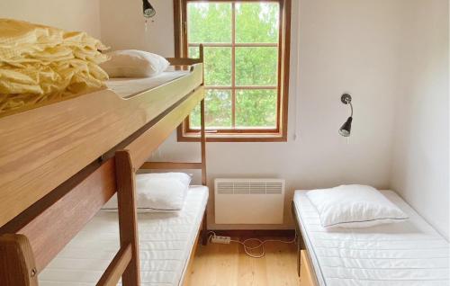 LöderupにあるAmazing Home In Lderup With Kitchenの二段ベッド2台と窓が備わる客室です。