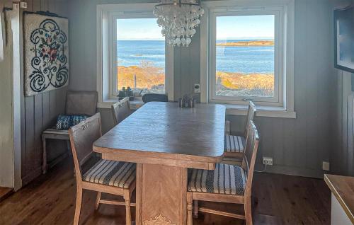 a dining room table and chairs with a view of the ocean at Nice Home In Smøla With House Sea View in Smøla