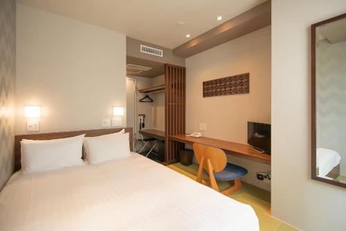 a hotel room with a bed and a desk at Hotel A'bant Shizuoka in Shizuoka