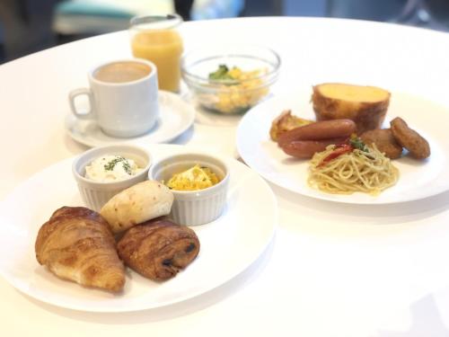 zwei Teller Essen auf einem Tisch mit Frühstückszutaten in der Unterkunft Citadines Shinjuku Tokyo in Tokio