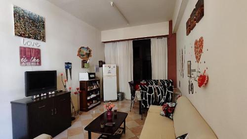 een woonkamer met een bank en een tv bij -= Studio Love =- in Xylophaghou