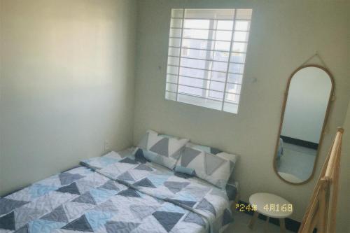um quarto com uma cama e um espelho em Nhà Tú Homestay em Thôn Mỹ Phước