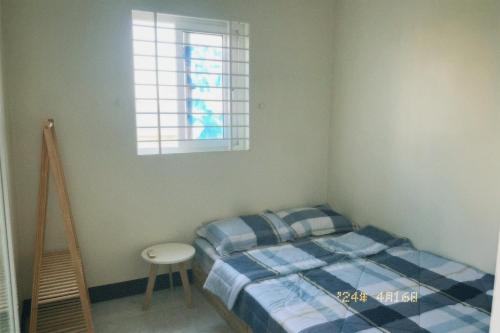 um pequeno quarto com uma cama e uma janela em Nhà Tú Homestay em Thôn Mỹ Phước