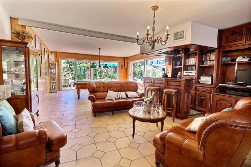 Elle comprend un grand salon doté d'un mobilier en cuir et d'un lustre. dans l'établissement Villa cafe marrec 8, à Port-Louis