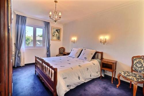 a bedroom with a bed and a chair and a window at Villa cafe marrec 8 in Port-Louis